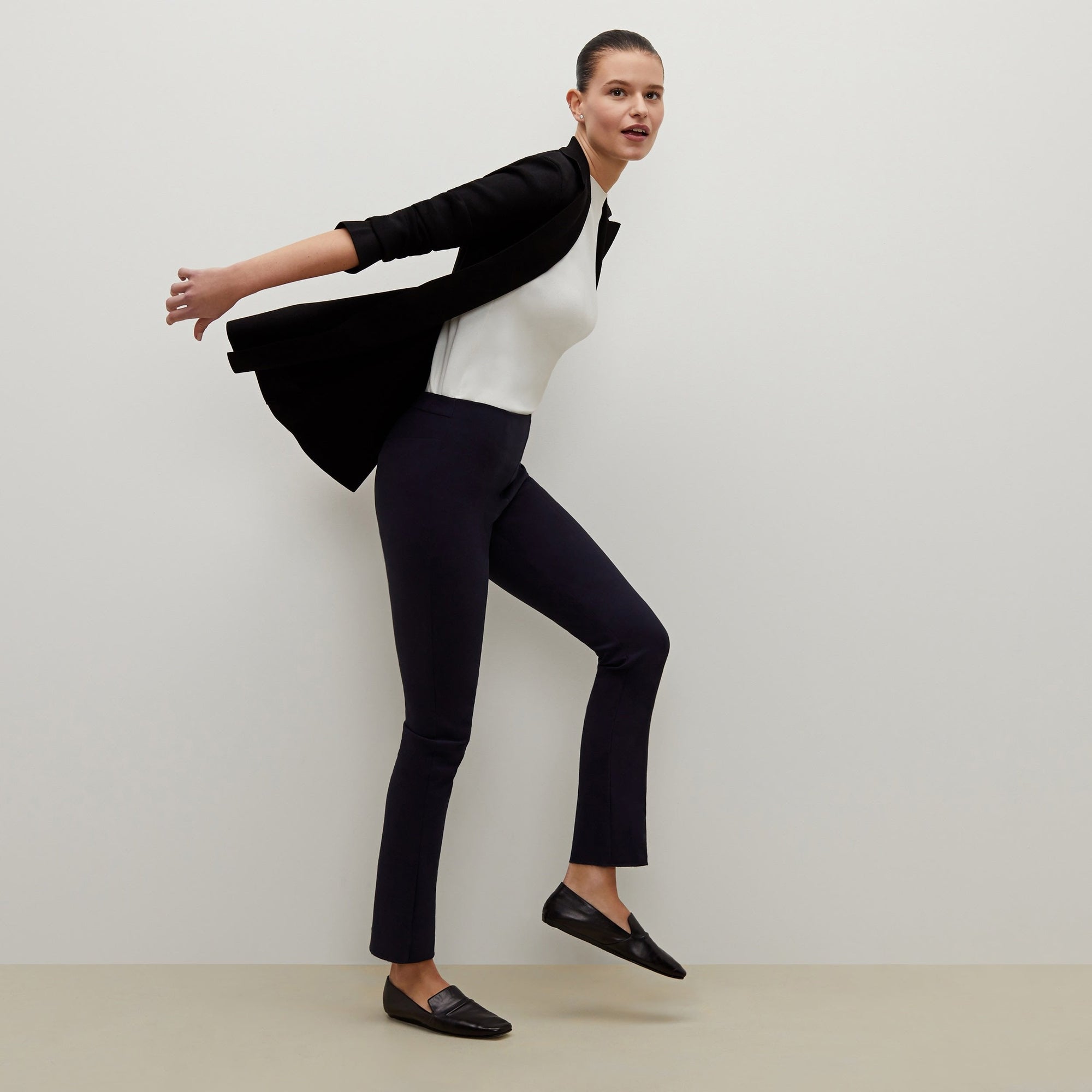 Side image of a woman standing wearing the foster pant in dark navy | Exclude