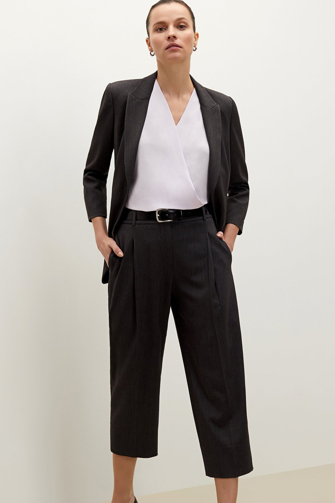 Front image of a woman standing wearing the Isadora pant in charcoal | Grid Hover | Exclude