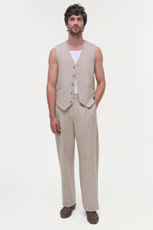 Beige textured vest with button front and matching trousers, worn over white undershirt.