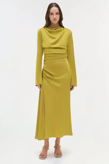 Chartreuse satin midi dress with long sleeves, ruched waist, and side slit, styled with nude platform sandals.