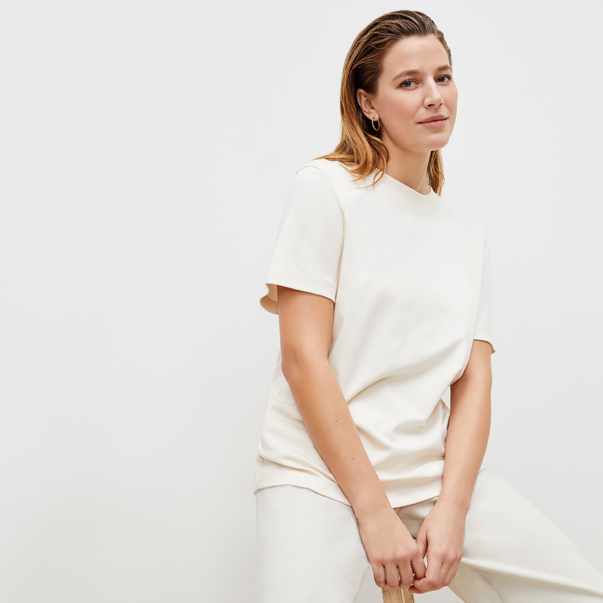 Front image of a woman standing wearing the leslie top in compact cotton in ivory | Exclude