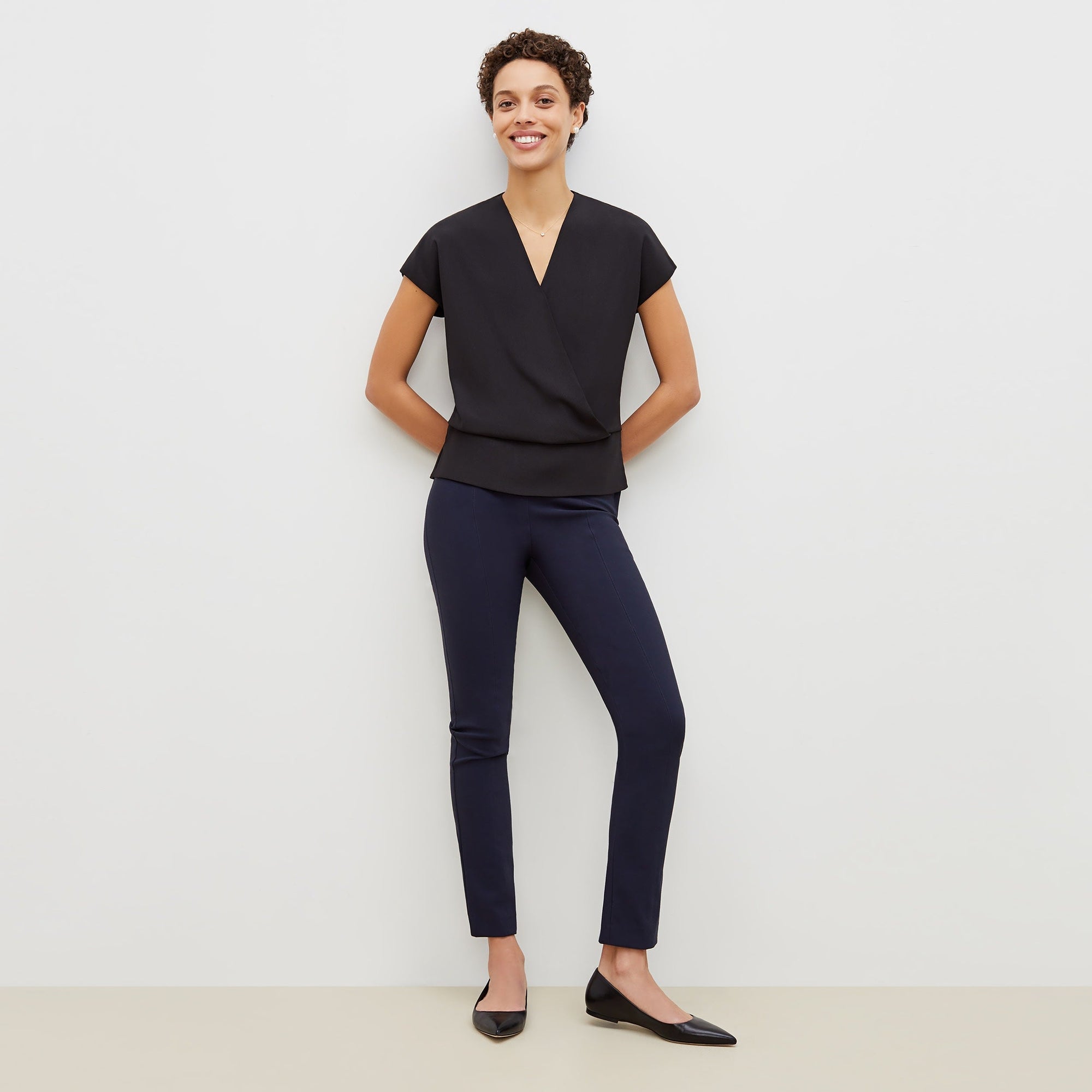 Front image of a woman standing wearing the foster pant in dark navy | Exclude