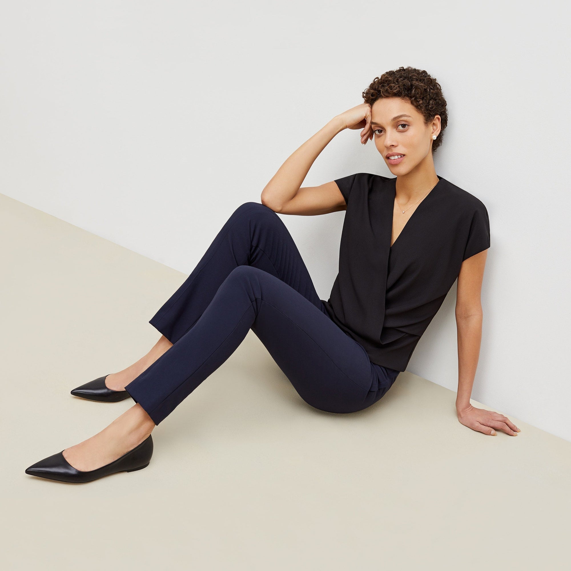Front image of a woman standing wearing the foster pant in dark navy | Exclude