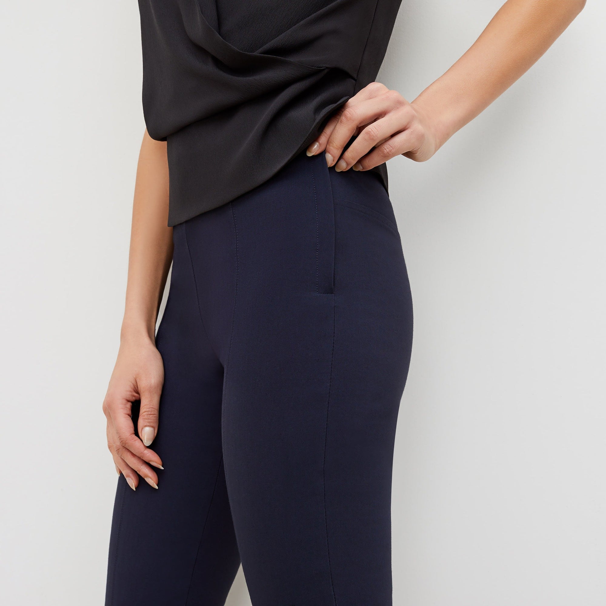 Side image of a woman standing wearing the foster pant in dark navy | Exclude