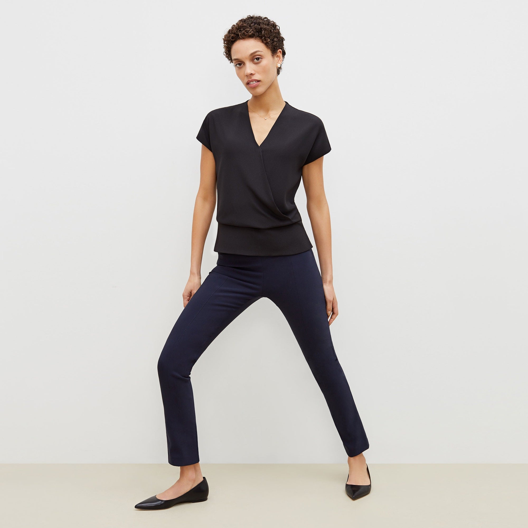 Front image of a woman standing wearing the foster pant in dark navy | Exclude