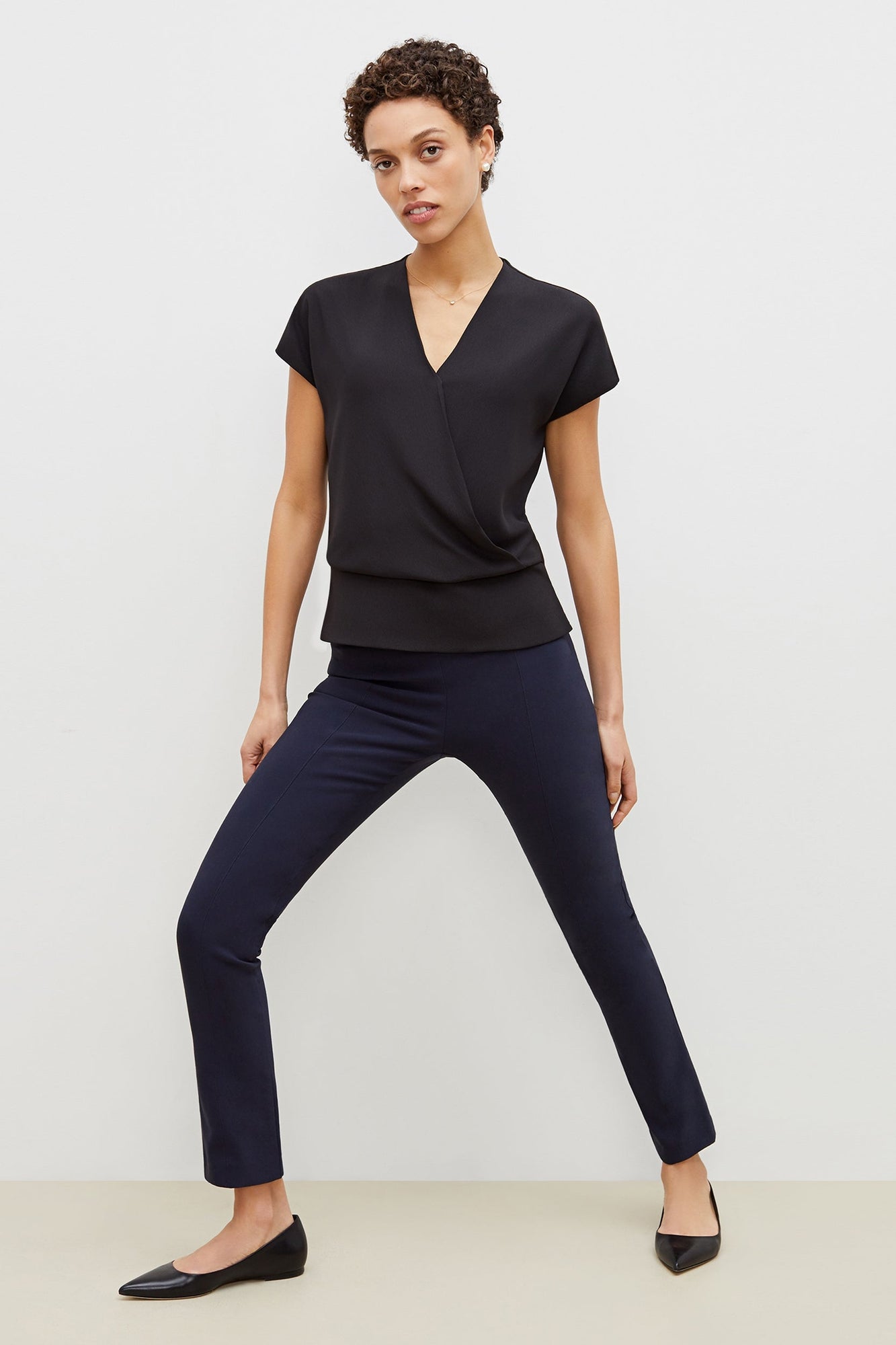 Front image of a woman standing wearing the foster pant in dark navy | Exclude