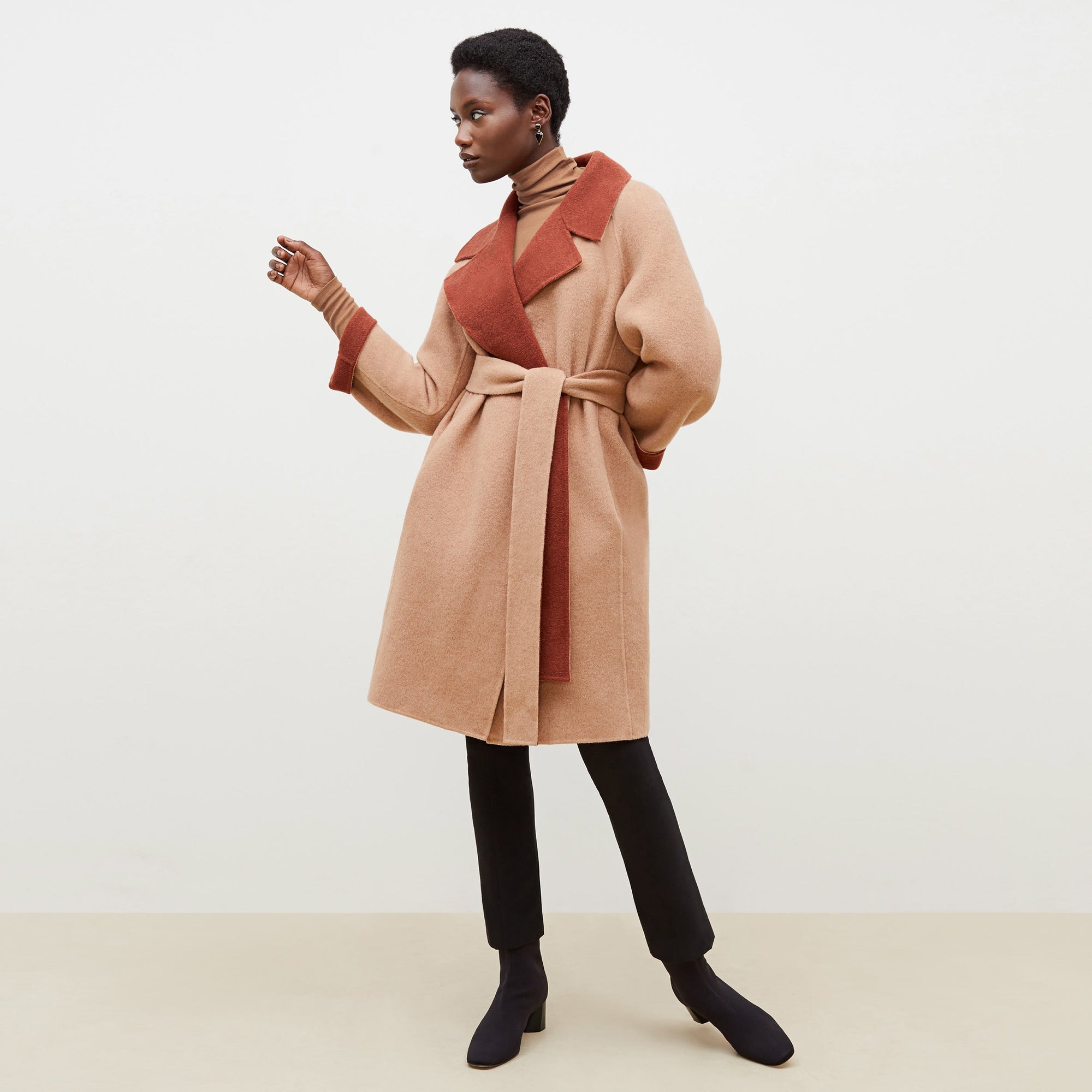 Front image of a woman standing wearing the axam top in camel | Exclude