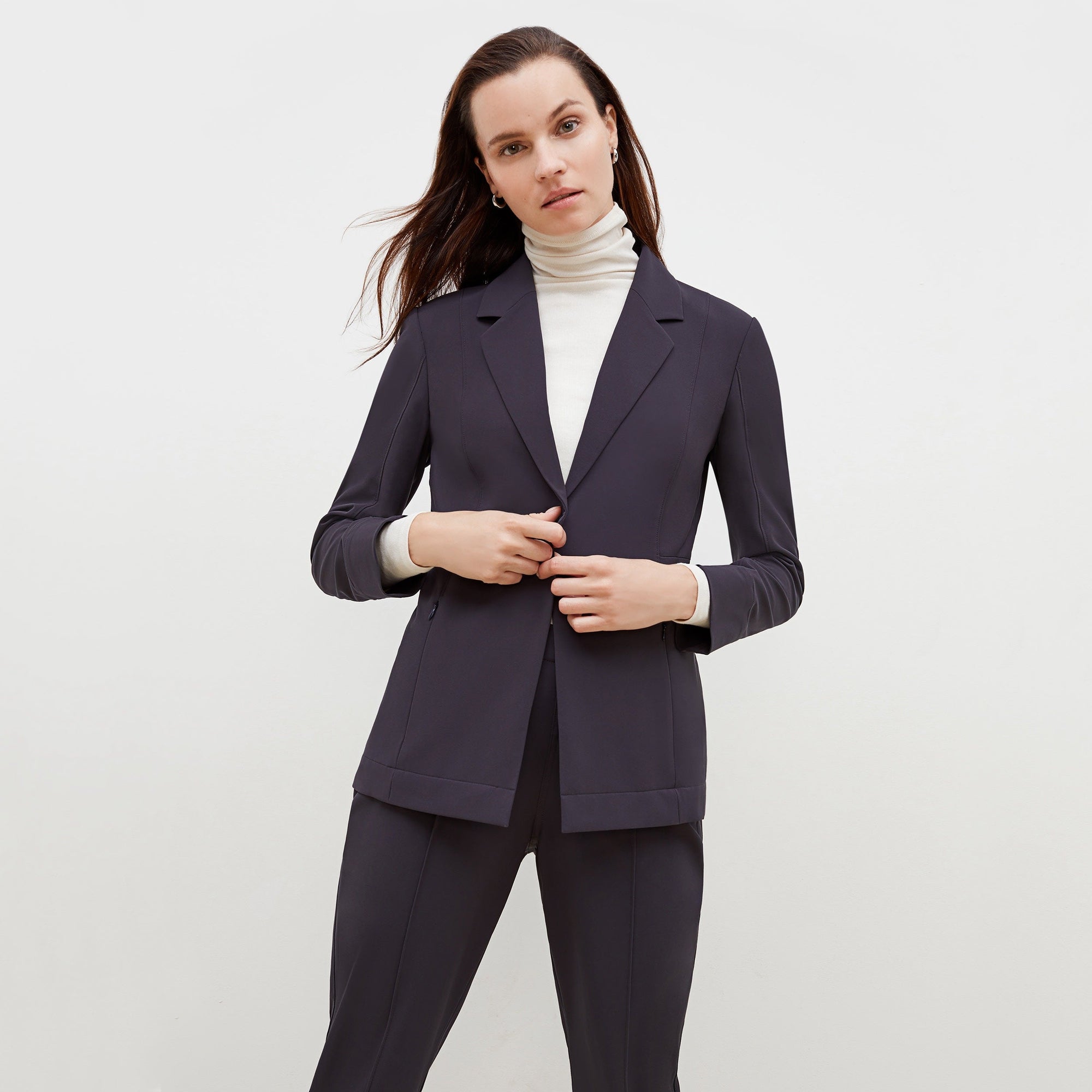 Front image of a woman standing wearing the axam top in ivory | Exclude