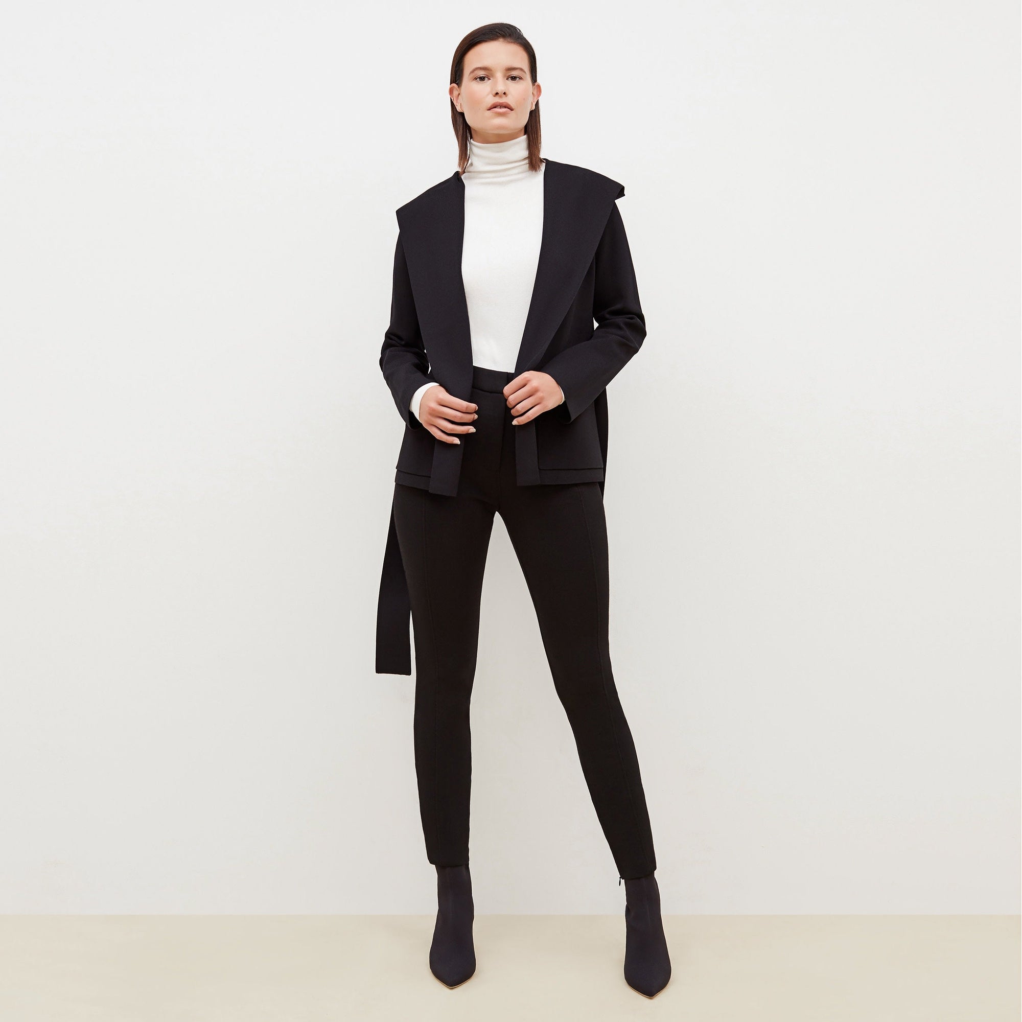 Front image of a woman standing wearing the axam top in ivory | Exclude