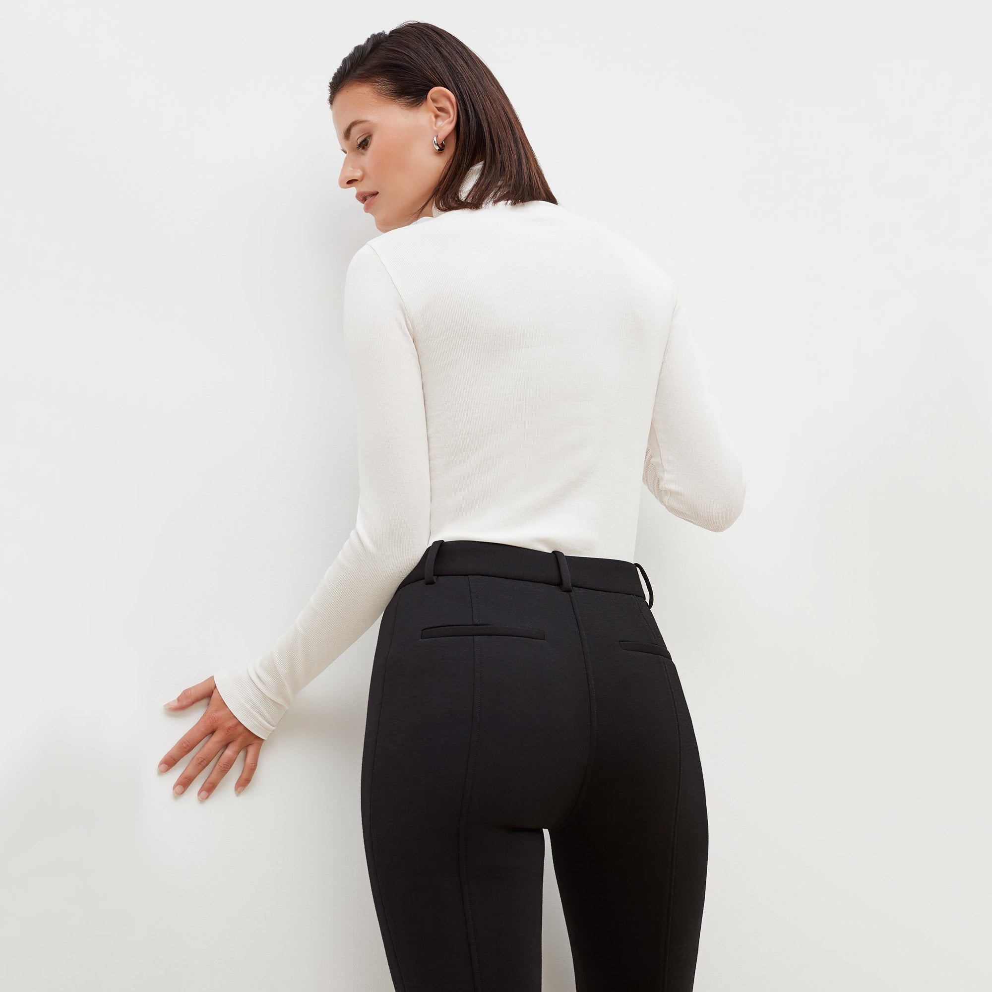 Back image of a woman standing wearing the axam top in ivory | Exclude
