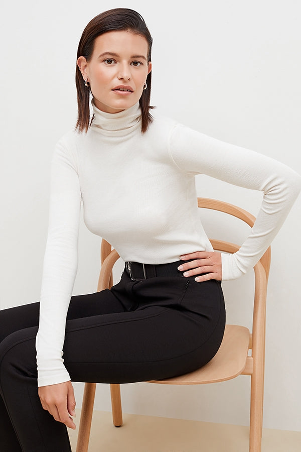 Front image of a woman standing wearing the axam top in ivory | Grid | Exclude
