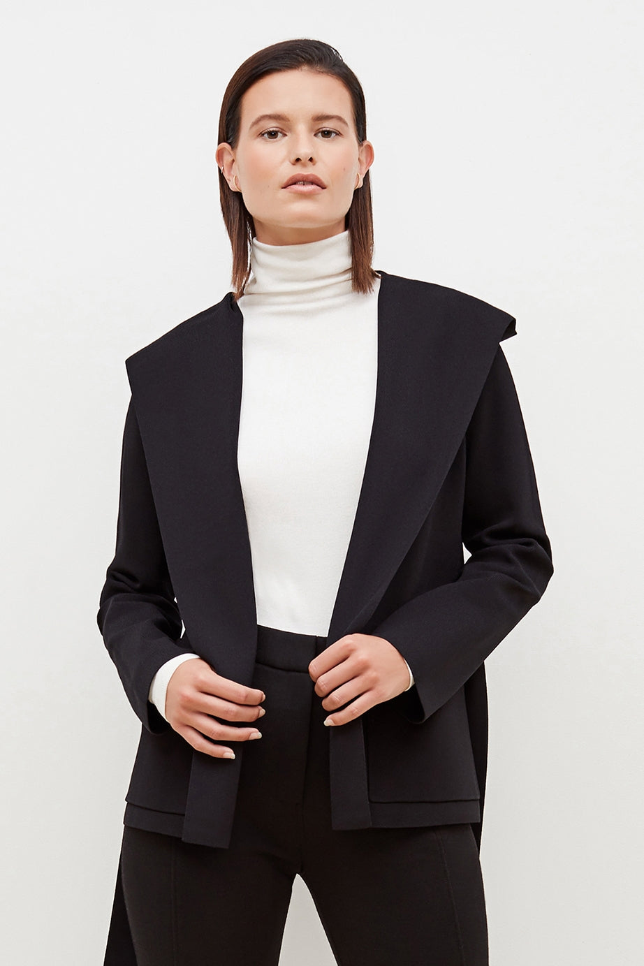 Front image of a woman standing wearing the axam top in ivory | Exclude