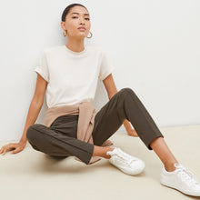 Front image of a woman sitting wearing the leslie top in compact cotton in ivory | Lead