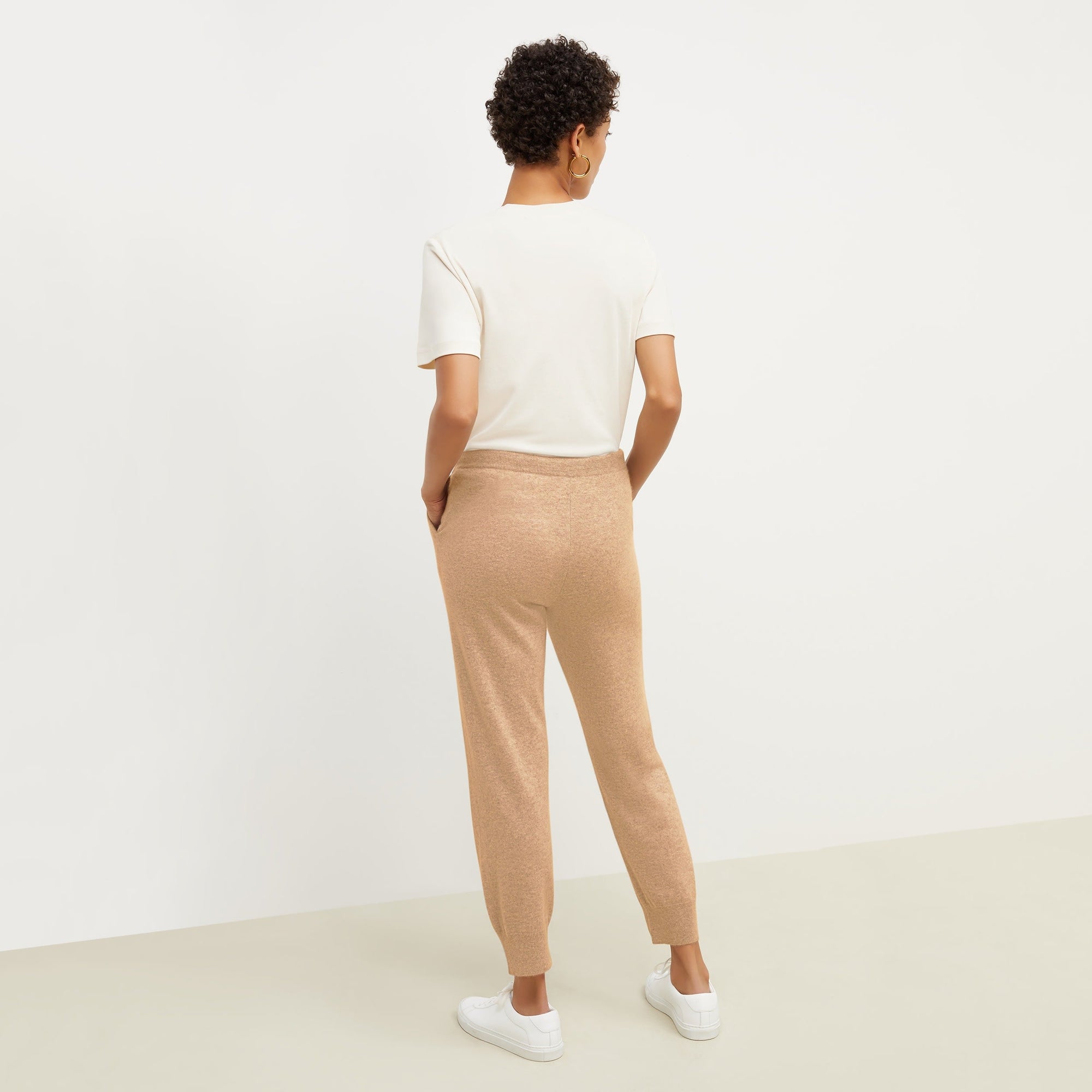 Back image of a woman standing wearing the leslie top in compact cotton in ivory | Exclude
