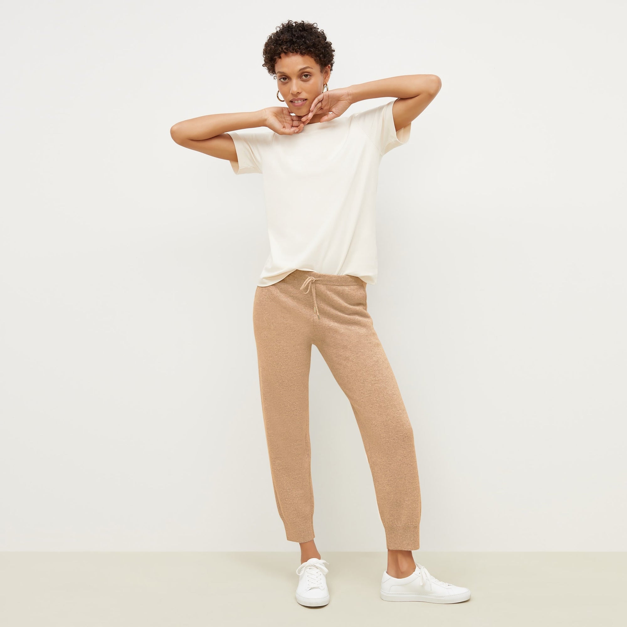 Front image of a woman standing wearing the leslie top in compact cotton in ivory | Exclude