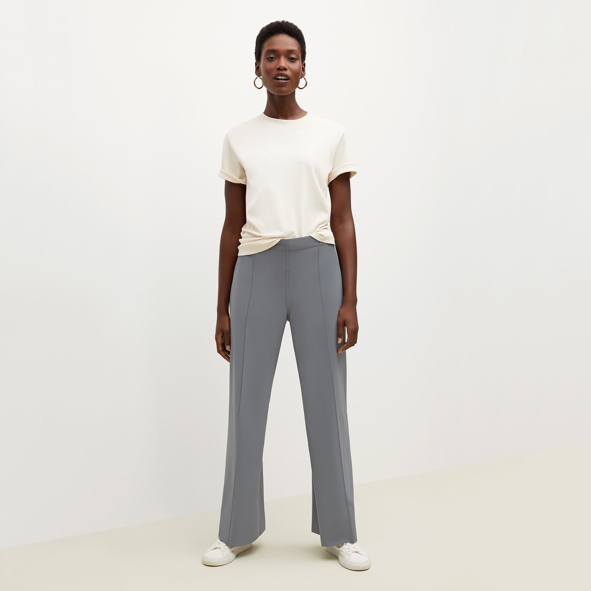 Front image of a woman standing wearing the leslie top in compact cotton in ivory | Exclude
