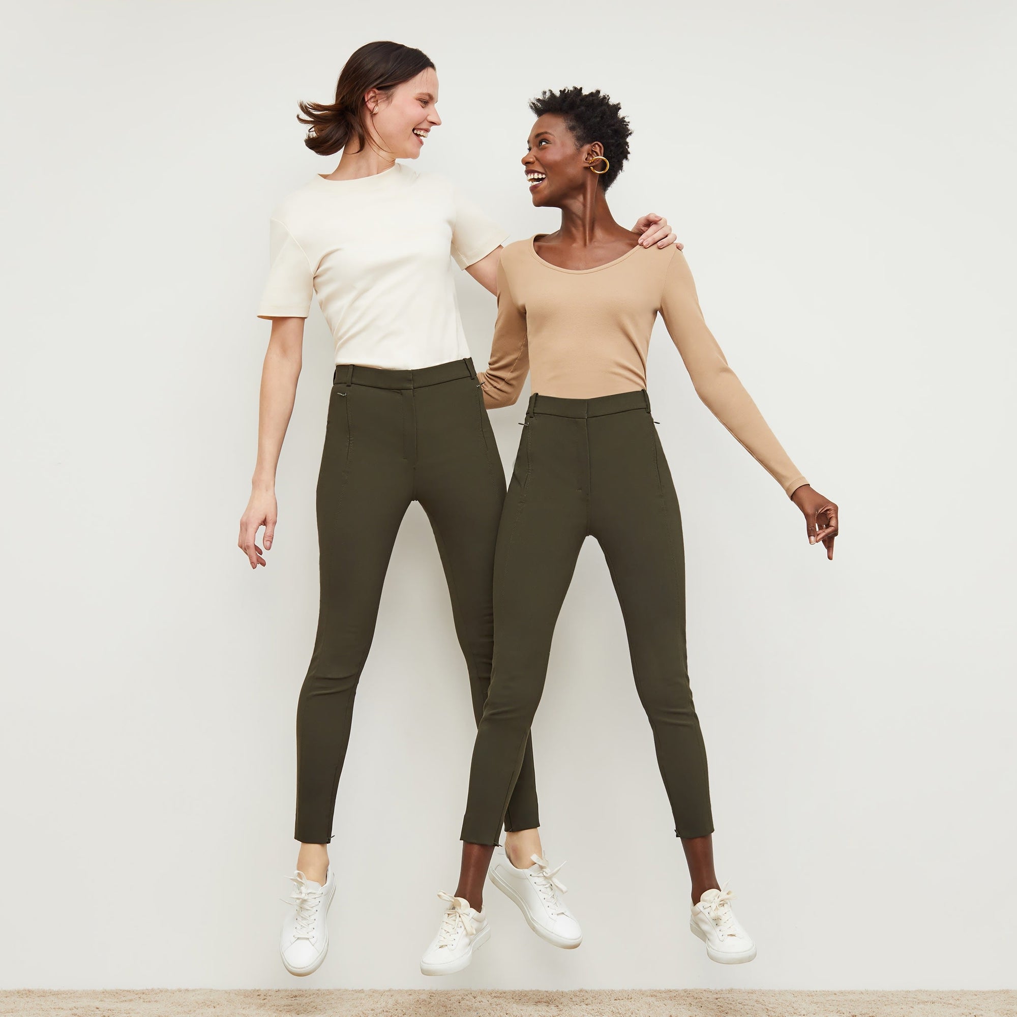 Front image of a woman standing wearing the curie pant in dark olive | Exclude