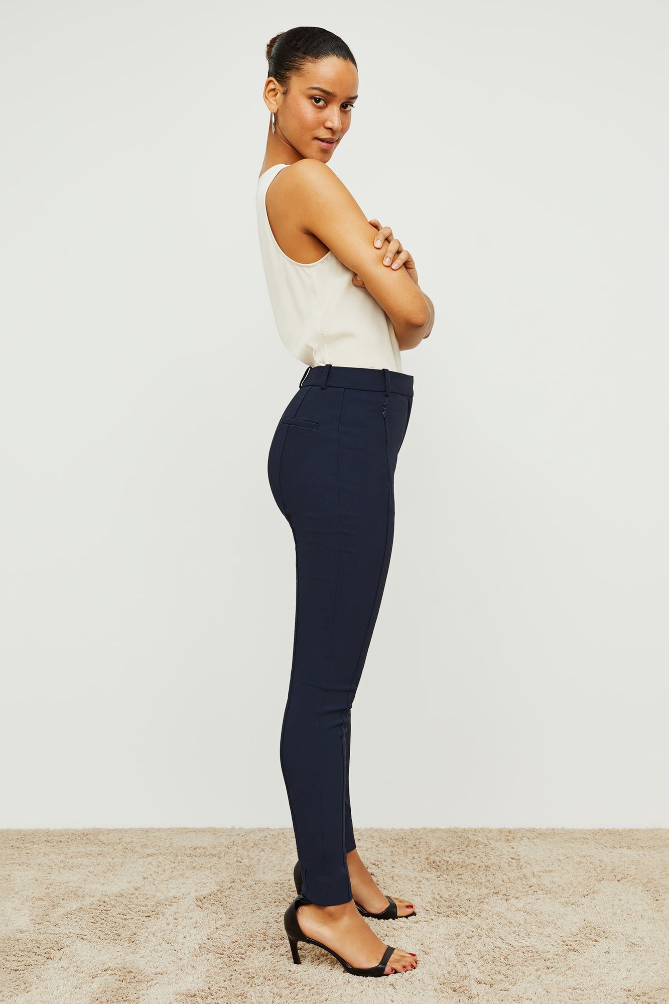 Side image of a woman standing wearing the curie pant in dark navy | Grid Hover | Exclude