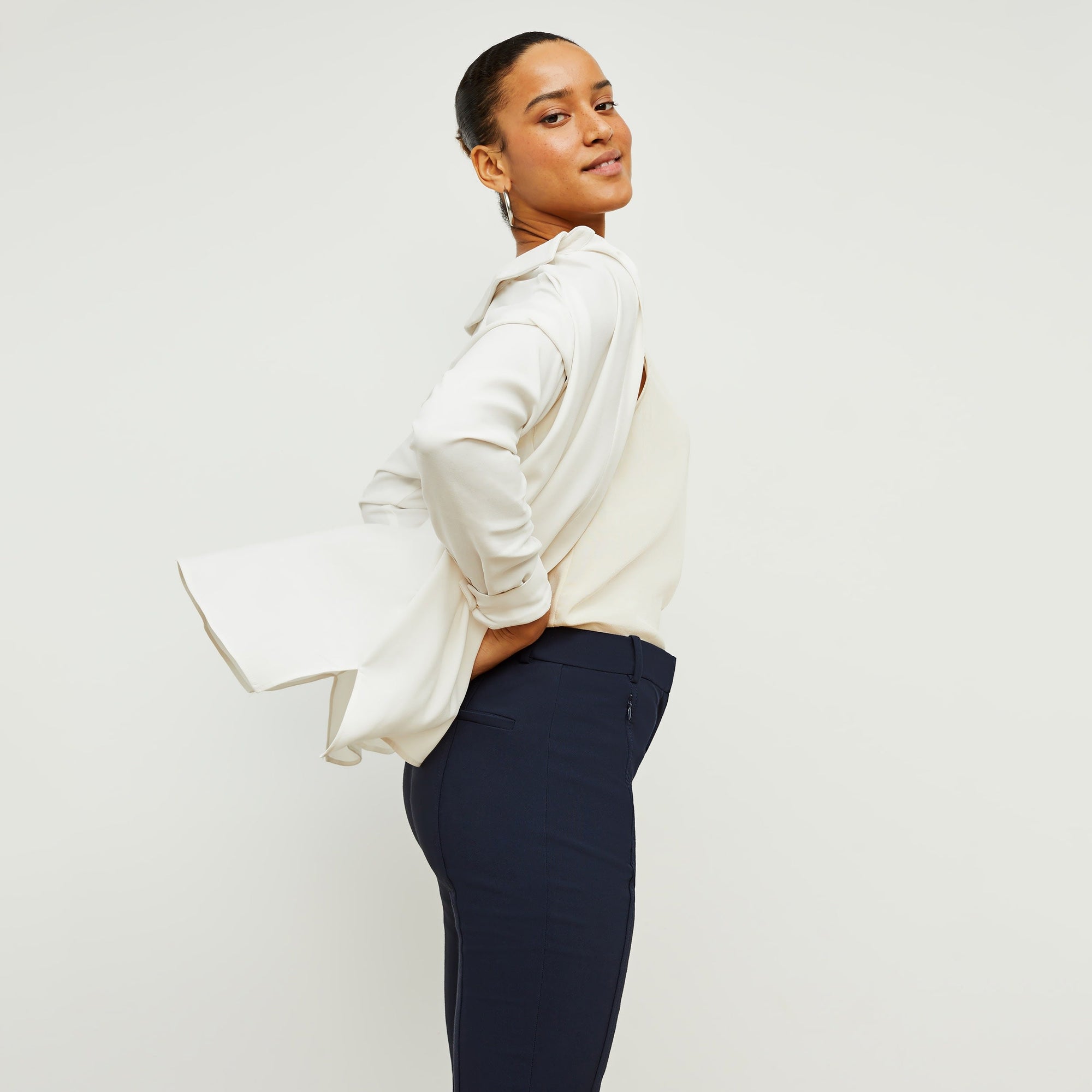 Side image of a woman standing wearing the Vicky Tank—Washable Silk in Pearl | Exclude