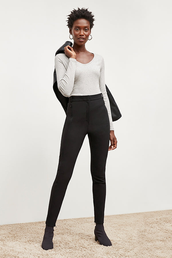 Front image of a woman standing wearing the curie pant in black | Exclude