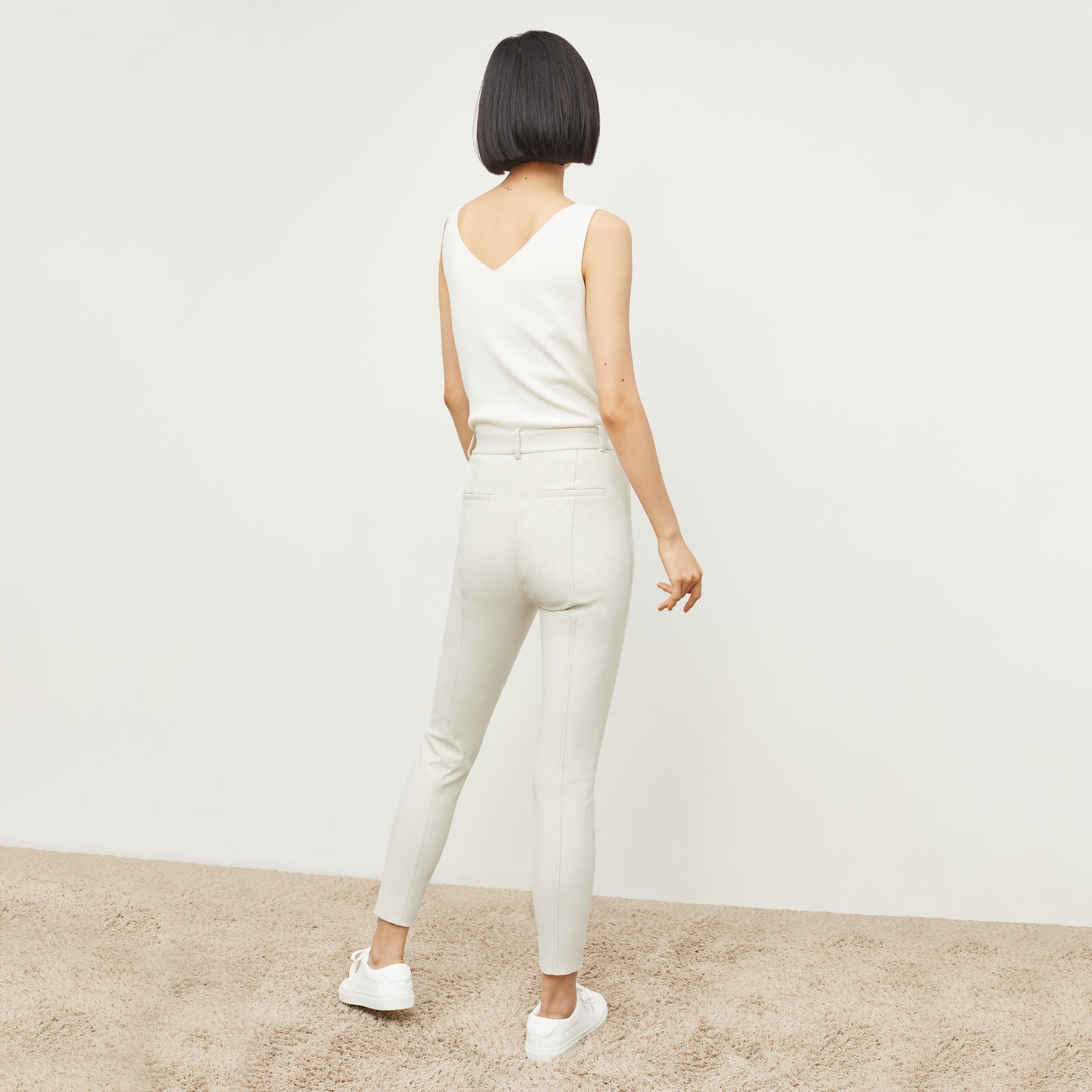 Back image of a woman standing wearing the Curie Pant—Everstretch in Bone