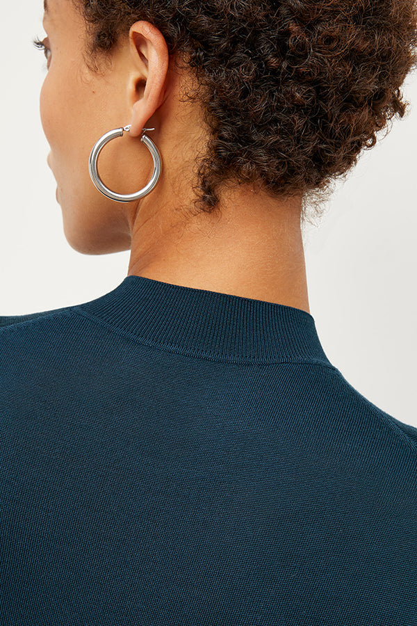 Detail image of a woman standing wearing the Claressa Earrrings Medium in Silver | Grid Hover | Exclude