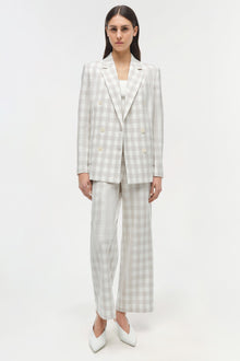 Cream and beige gingham double-breasted blazer with matching wide-leg trousers and white boots.