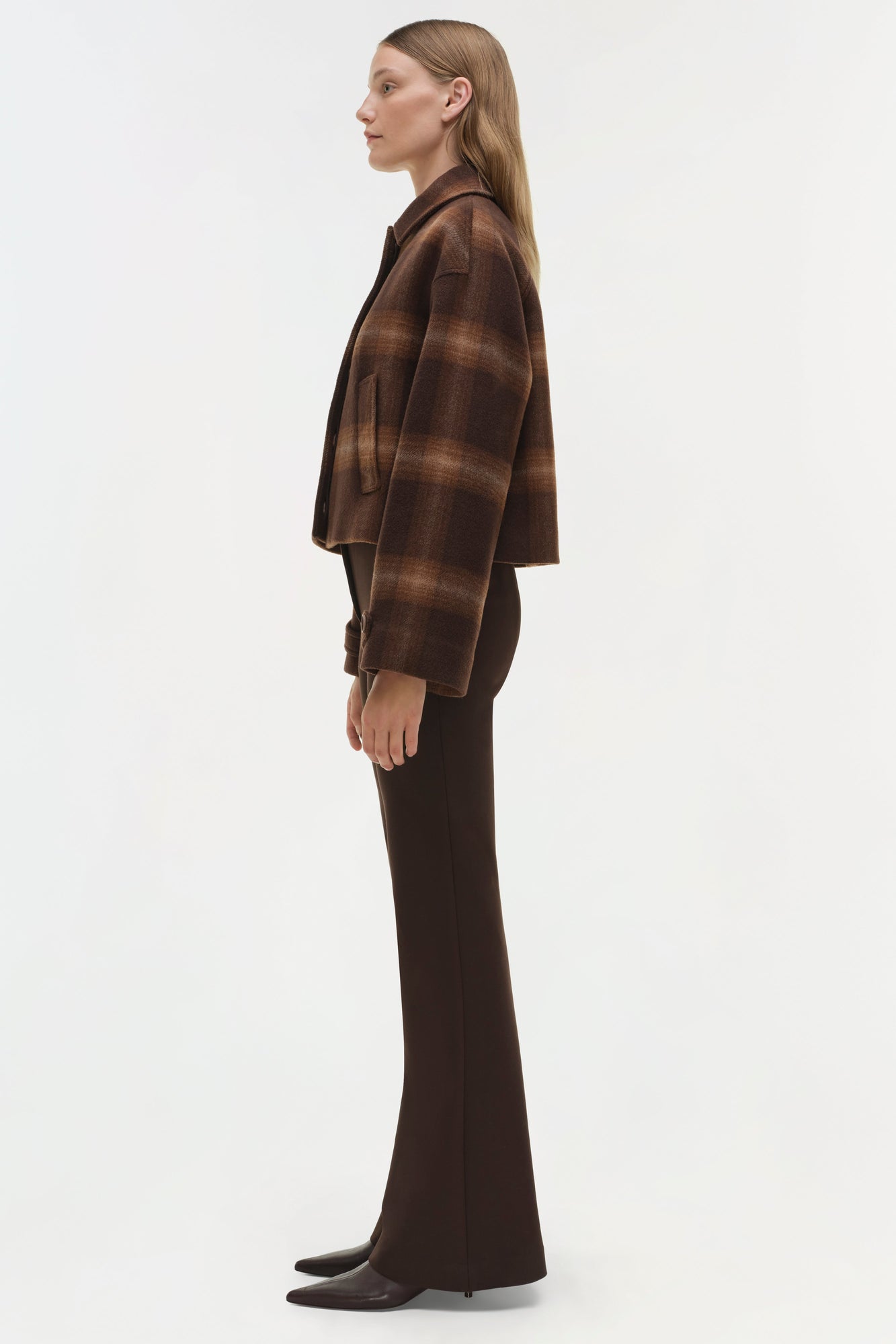 Brown plaid wool jacket with collar worn over dark trousers and black shoes.