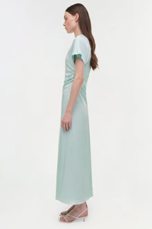 Pale green satin midi dress with draped side detail and short sleeves, shown on model in profile view.