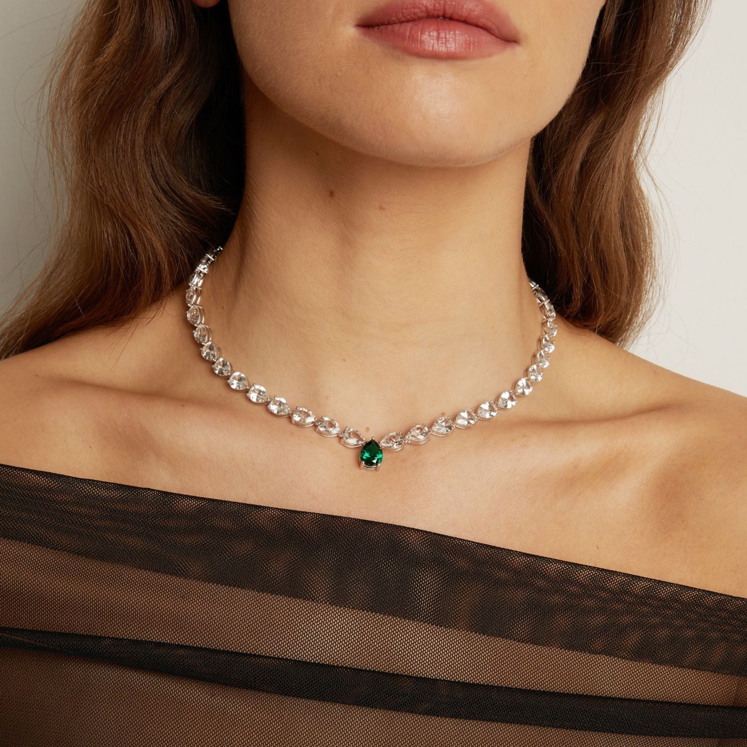 Necklace with a green gemstone worn by a person