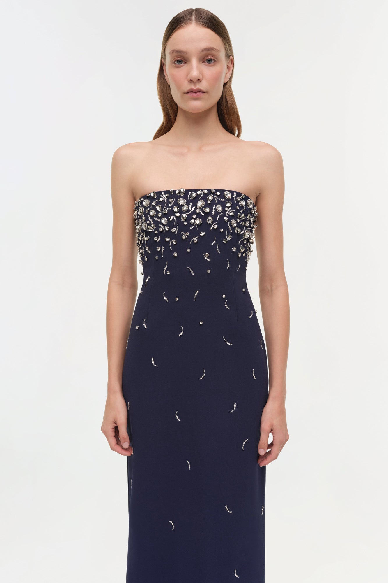 Navy strapless gown with silver beaded embellishments concentrated on bodice, scattered down skirt.