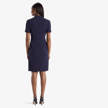 Back image of a woman standing wearing theTory Dress in dark iris