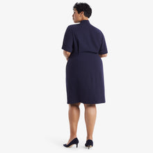 Back image of a woman standing wearing theTory Dress in dark iris