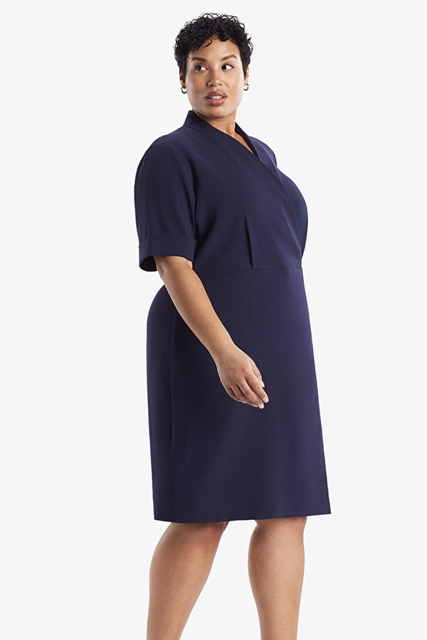 Side image of a woman standing wearing theTory Dress in dark iris | Plus Hover | Exclude