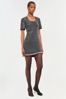 Black and white houndstooth mini dress with short sleeves and embellished trim at hem.