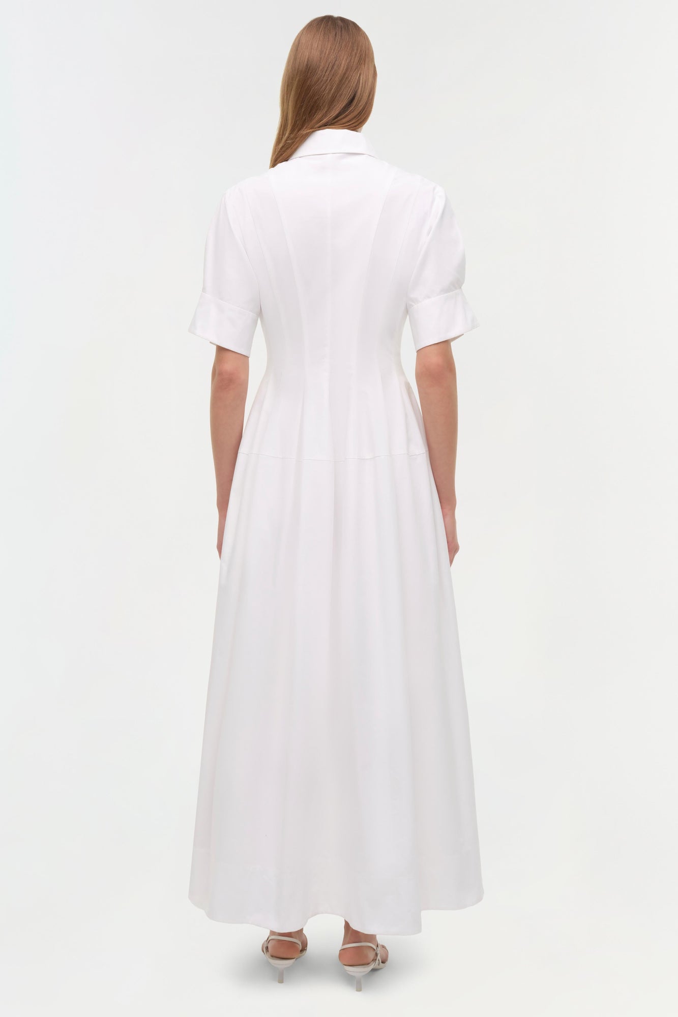 White cotton shirt dress with short sleeves and A-line skirt, shown from back on model.