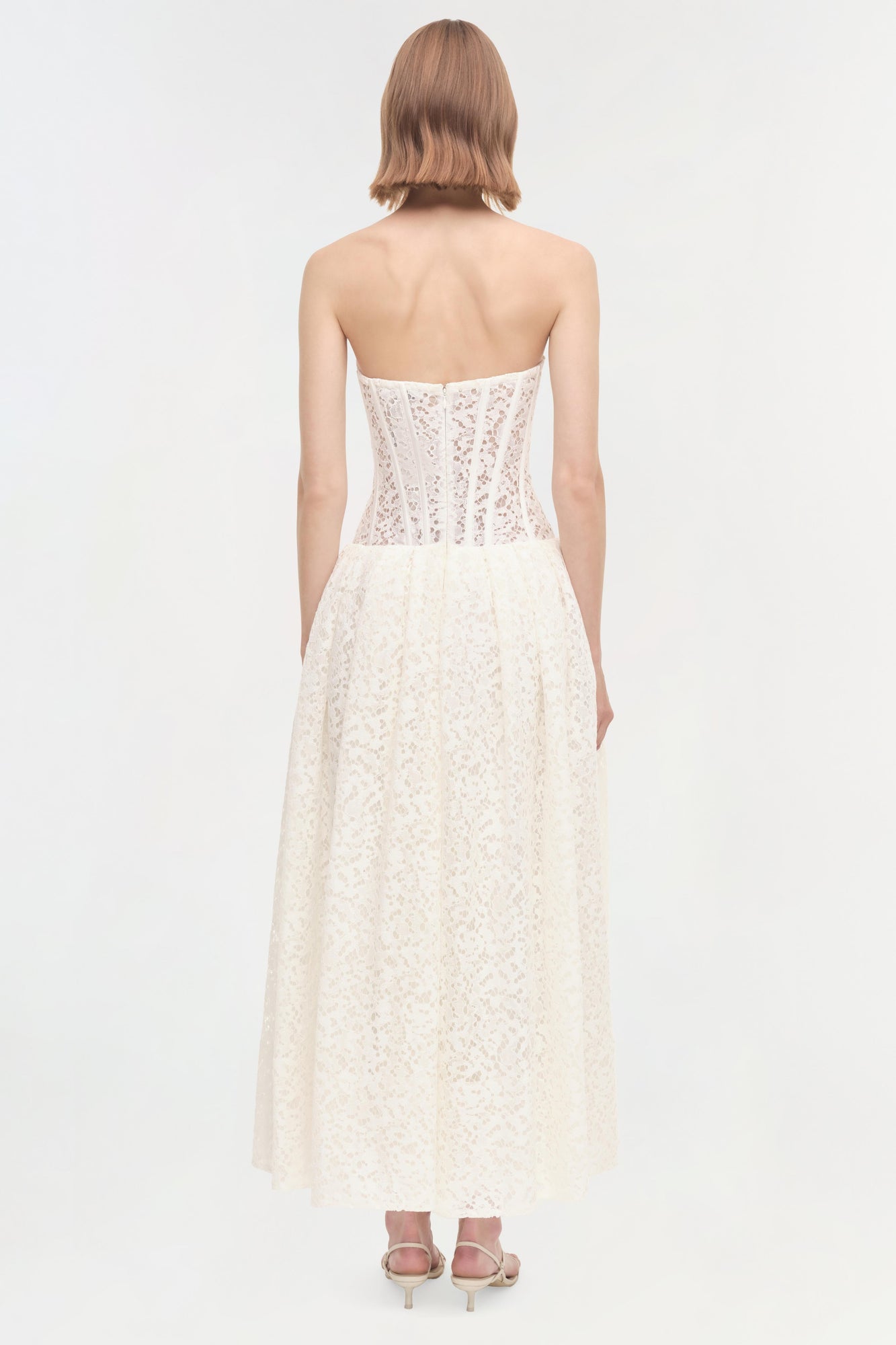 White lace strapless dress with sequined corset bodice and full skirt, shown from back view.