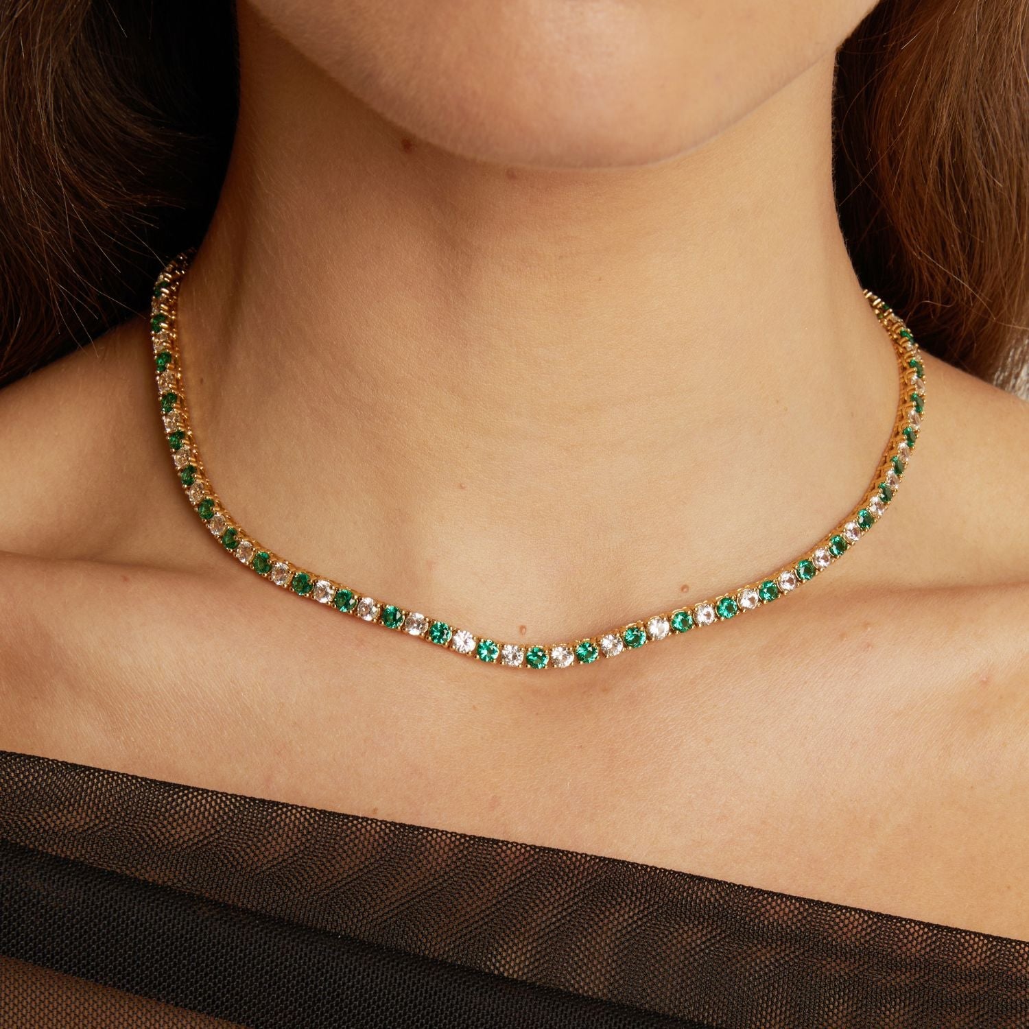 Model. Necklace with green gemstones worn by a person