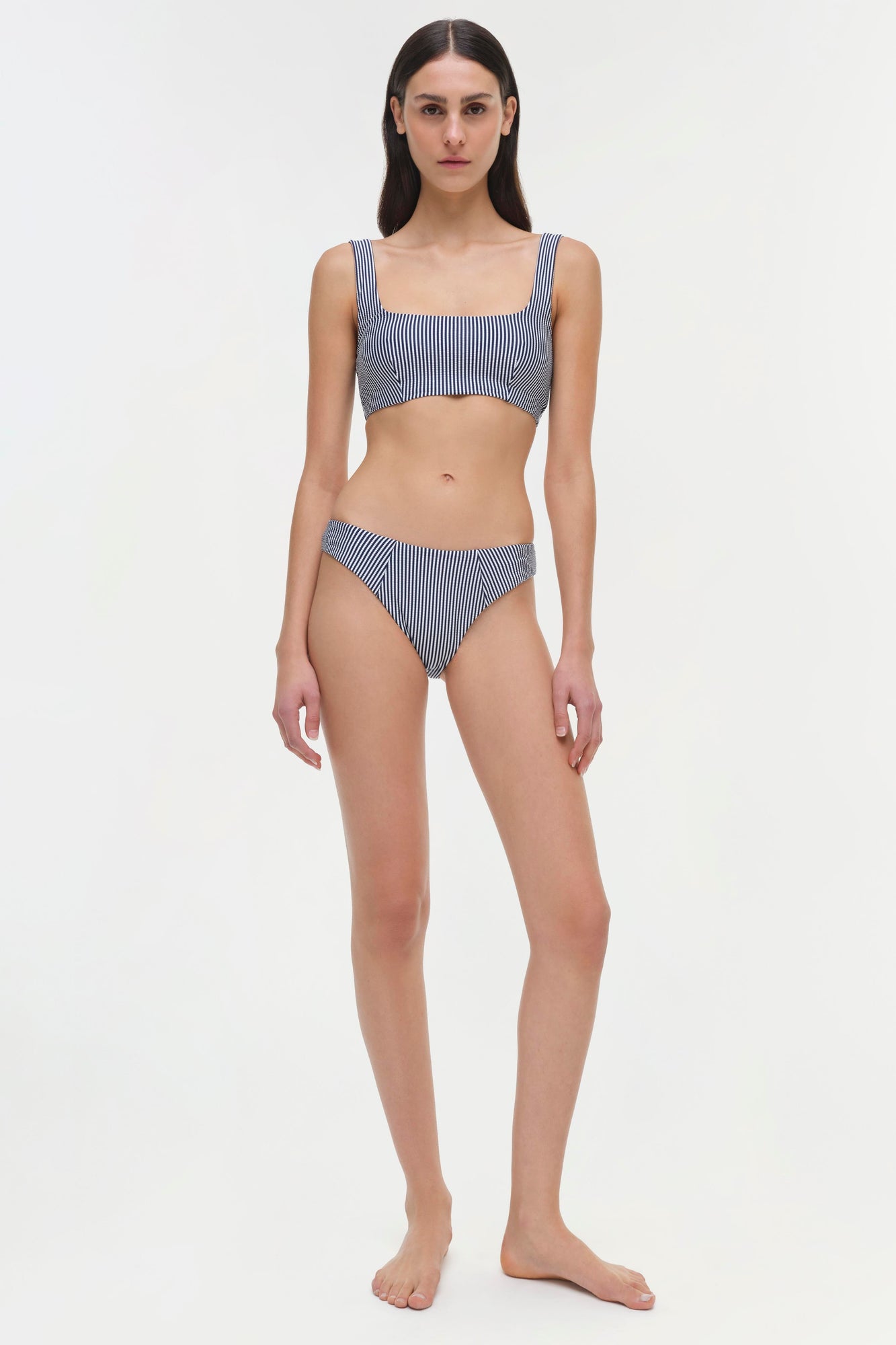 Blue and white vertical striped bikini bottom with ruched side detail on model.