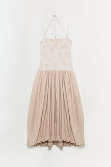 Sleeveless midi dress in cream and beige with geometric print bodice, tie halter neckline, and pleated skirt.