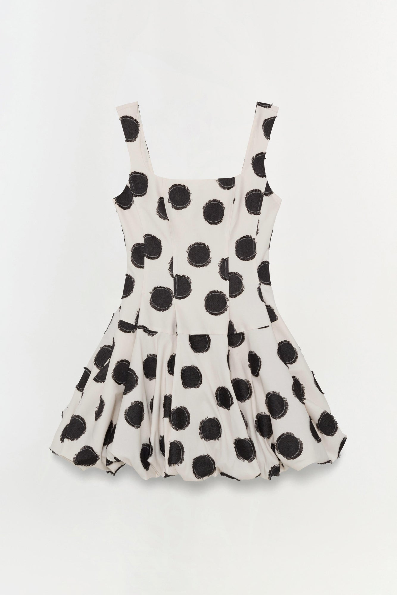 Cream mini dress with black polka dot print and sleeveless square neckline.
