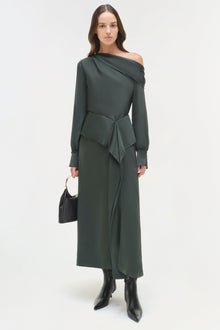 Woman wearing dark green satin midi skirt with matching off-shoulder top, tied waist detail, and black boots.