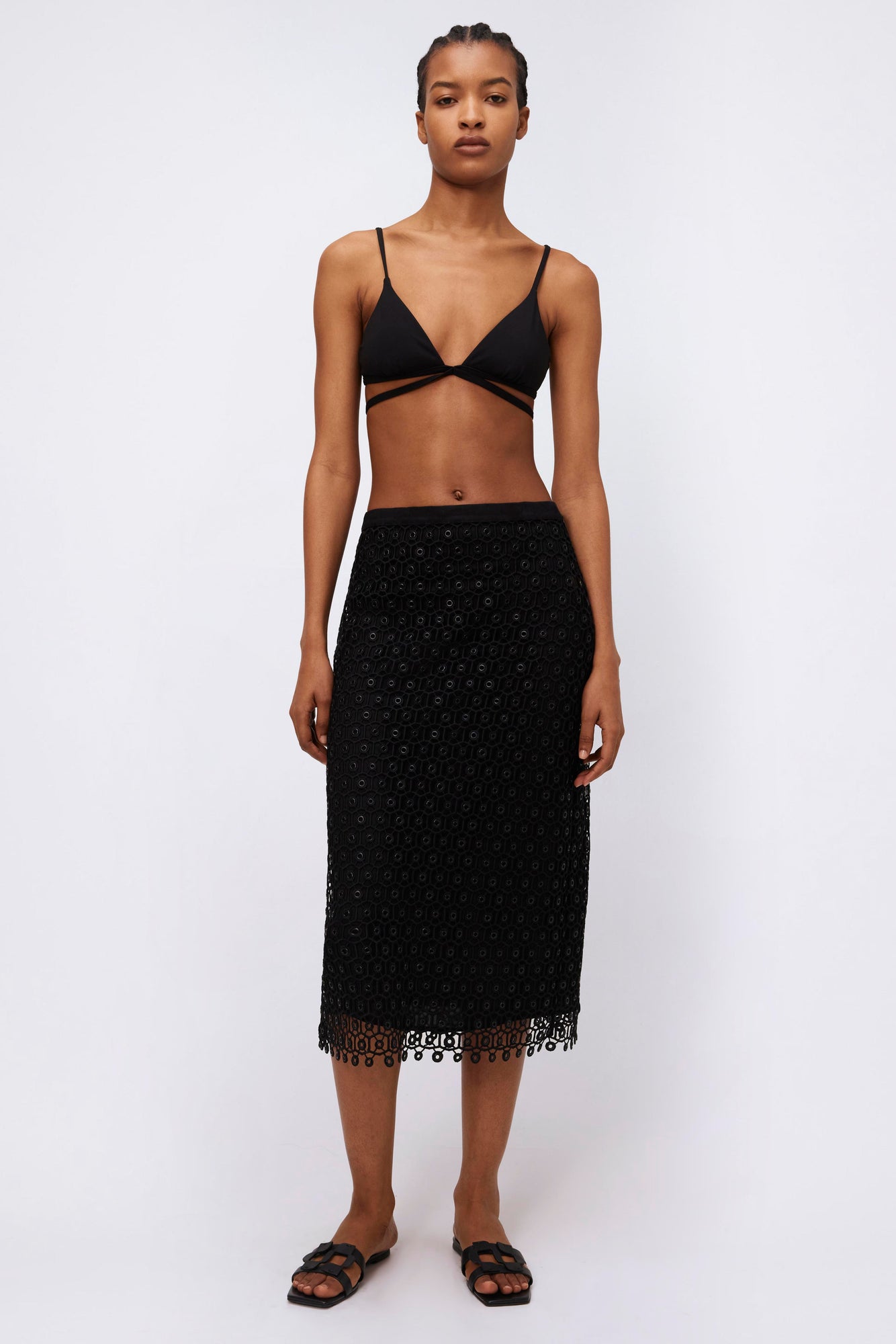 Black midi skirt with geometric eyelet pattern and lace trim hem.