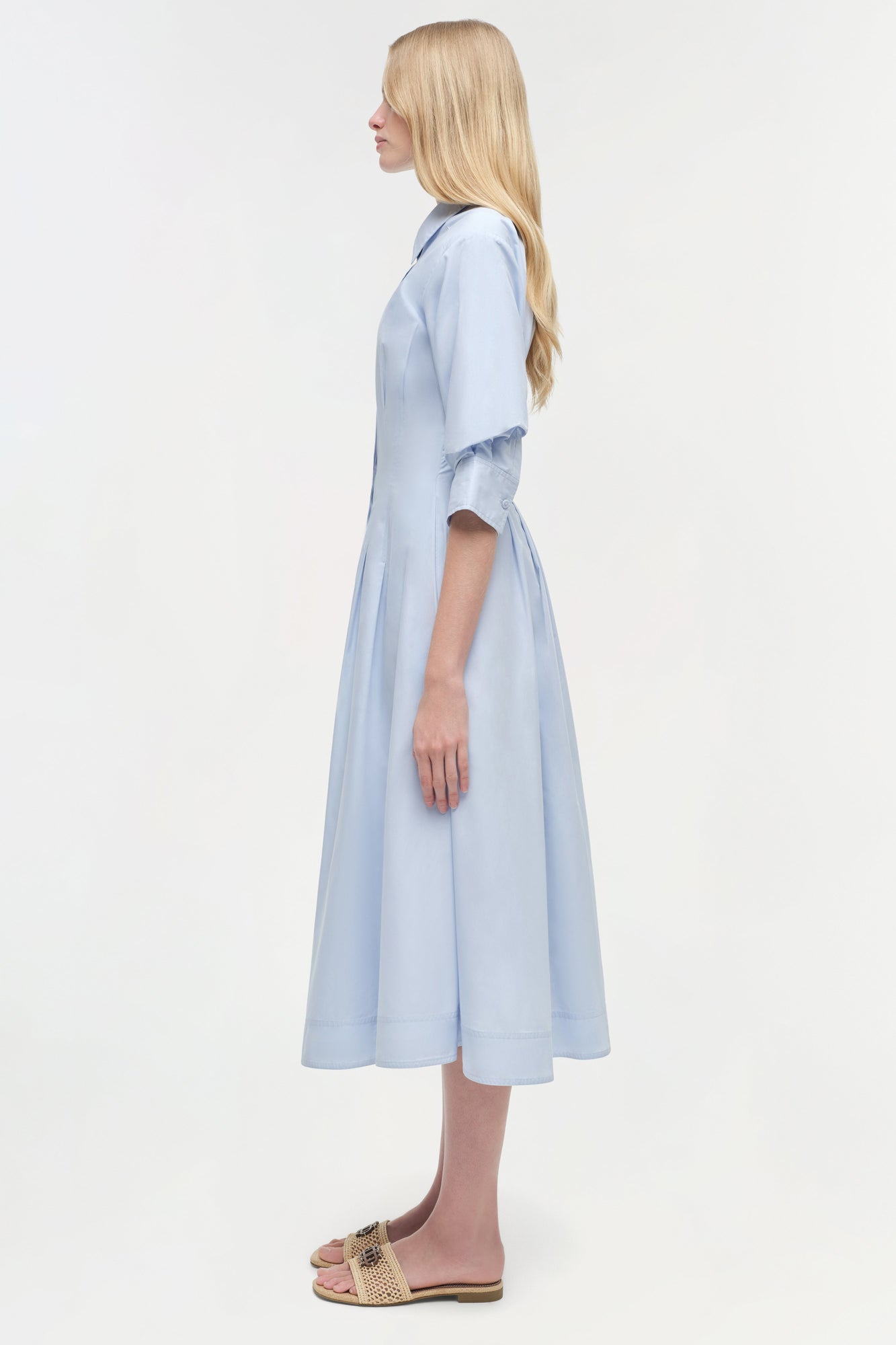 Light blue cotton midi dress with three-quarter sleeves and full skirt, shown on model in side view.