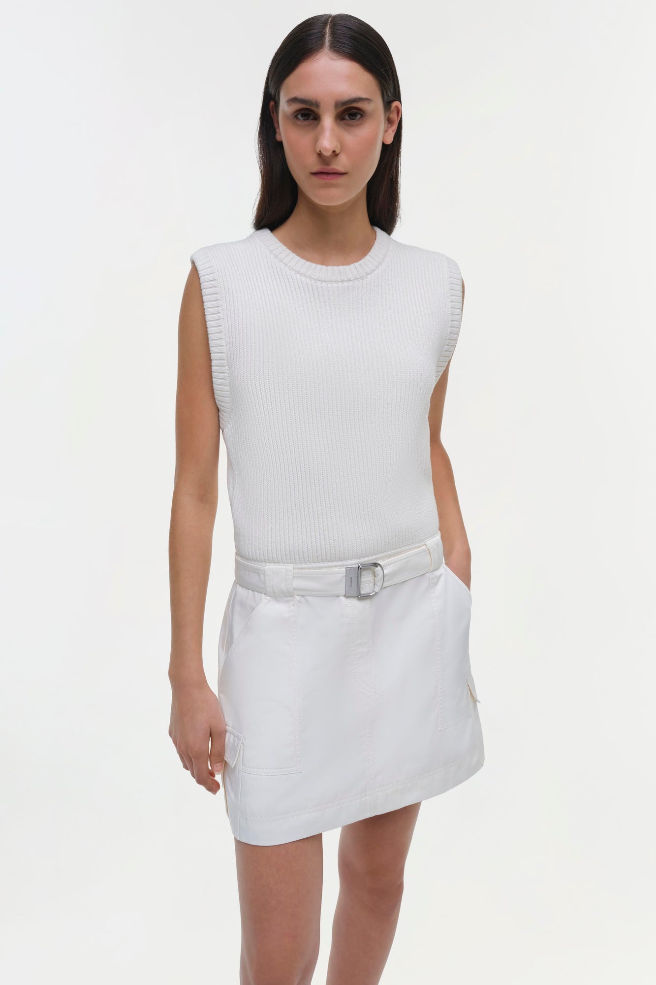 White sleeveless dress with ribbed knit top, white skirt with belt, and cargo pockets.