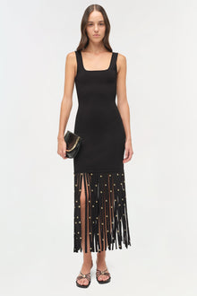 Black sleeveless midi dress with square neckline and fringed hem adorned with gold studs.