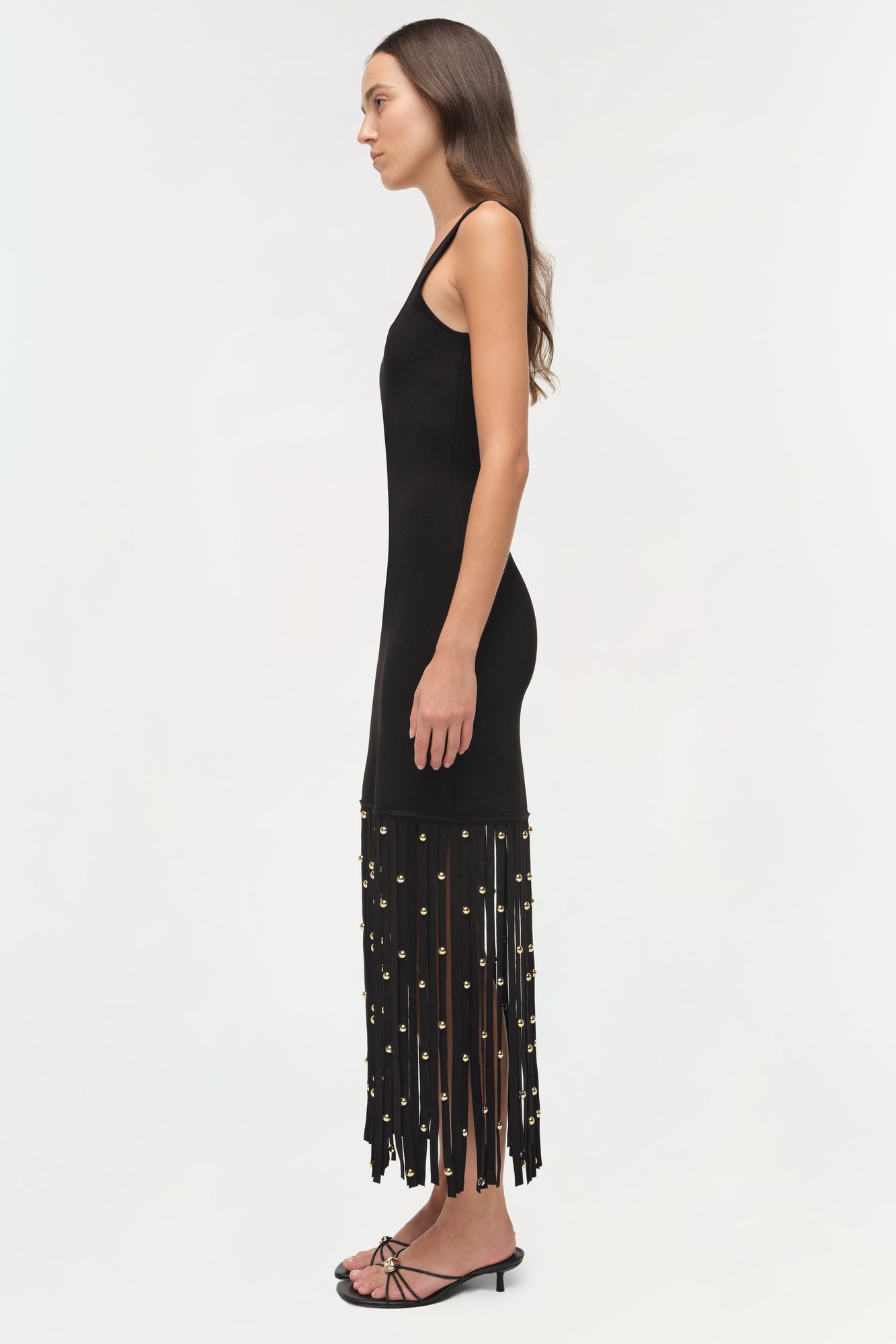 Black knit midi dress with thin straps and gold stud-embellished fringe hem.