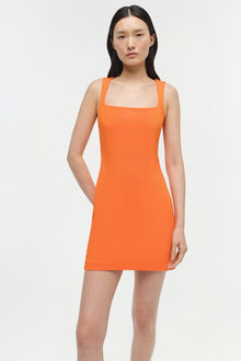 Woman wearing a sleeveless orange mini dress with a square neckline against a white background.