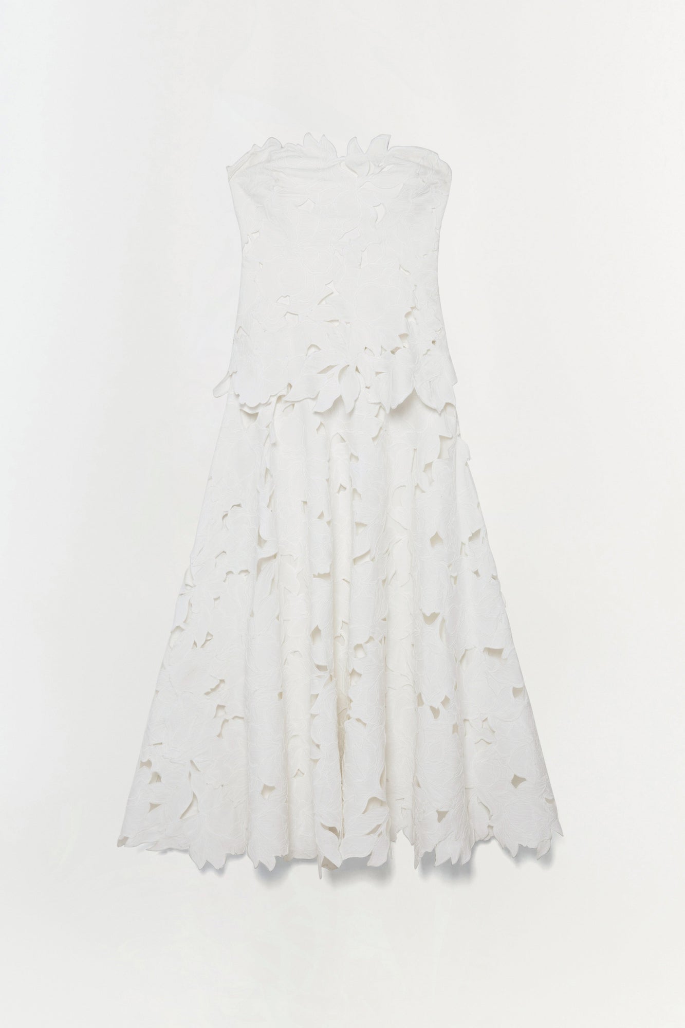 White sleeveless midi dress with leaf-shaped embroidered cutouts throughout bodice and skirt.