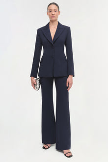 Navy single-breasted blazer with notch lapels worn with matching wide-leg trousers.